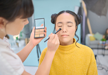 Image showing Makeup, artist and woman in studio with professional, cosmetics and creative, product and glamour. Asian, face and model with artistic makeover specialist, backstage for beauty, eyeshadow or contour