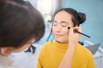 Image showing Beauty, cosmetic and beautician doing makeup on a woman for a creative photoshoot in a studio. Cosmetics, art and stylist preparing a young Asian female model with a routine for a photography job.