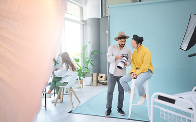 Image showing Photography, camera and photographer talking to a model to choose a image from the photoshoot in the studio. Creative, art and cameraman choosing the best picture with a woman on a artistic set.