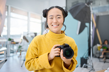 Image showing Smile, camera and portrait of a photographer working at a studio for a photoshoot. Happy, media and creative Asian woman shooting, filming or learning about photography production as a career