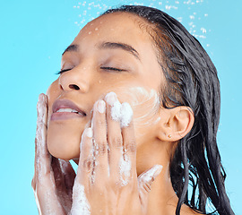 Image showing Shower foam, face and black woman cleaning with water liquid for hydration, beauty healthcare soap or skincare hygiene. Self care studio, spa salon and relax model washing isolated on blue background