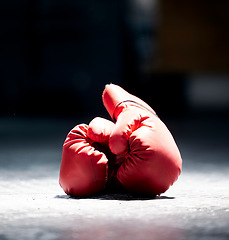 Image showing Boxing gloves, floor and sports on a dark background in studio for health, competition or exercise. Fitness, leather and protective sportswear for a boxer or athlete in competitive fighting