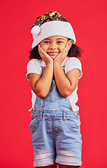 Image showing Little girl, face and portrait smile for Christmas, celebration or surprise isolated on a red studio background. Happy child smiling in happiness with hands looking adorable for festive season gift