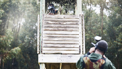 Image showing Paintball, aim and man shooting while playing a action match on an outdoor battlefield competition. Focus, gear and male military soldier player aiming to shoot with a weapon at a game at an arena.