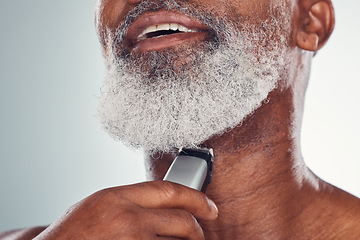 Image showing Grooming, skincare and man shaving beard on face isolated on a grey studio background. Cleaning, smile and African senior model with a tool for facial hair removal, hygiene and routine on a backdrop
