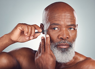 Image showing Grooming, skincare and black man with a tweezers for hair removal isolated on a studio background. Cleaning, beauty and face of an African senior model with a tool for facial care on a grey backdrop