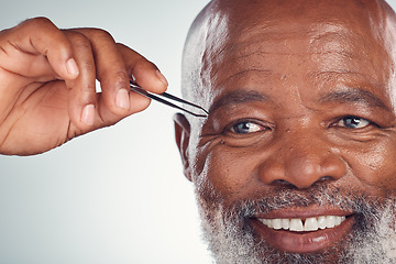 Image showing Grooming, smile and black man with tweezers for hair removal isolated on grey studio background. Cleaning, routine and senior African person with a product on face for shaping eyebrows on a backdrop