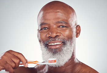 Image showing Dental, senior man portrait and toothbrush for oral hygiene in a studio for wellness and health. Gray background, happy face and elderly person with teeth cleaning product and toothpaste product