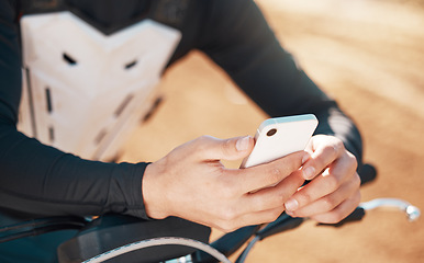 Image showing Moto cross, phone and man hands on a motorcycle and adventure dirt road outdoor for sports. Fitness, workout and athlete hand zoom of a young person texting or on motorcycle social media app