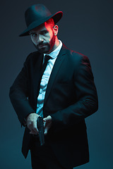 Image showing Man, suit or holding gun on dark studio background in secret spy, isolated mafia leadership or crime lord security. Model, gangster or hitman with pistol in style, formal or fashion clothes aesthetic
