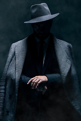 Image showing Mafia, fashion and mystery man in a suit isolated on a dark background in a studio. Business, vintage and stylish secret businessman for crime investigation, spy work and agent on a backdrop