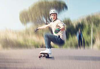 Image showing Skate, motion blur and fast with a sports man skating on an asphalt street outdoor for recreation. Skateboard, soft focus and speed with a male athlete or skater training outside on the road