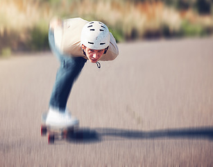 Image showing Skateboard, blurred motion and speed with a sports man skating on an asphalt road outdoor for recreation. Skate, soft focus and fast with a male athlete or skater training outside on the street