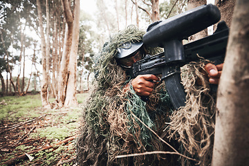 Image showing Paintball gun, forrest and man with aim by trees for outdoor war game, strategy or focus in natural camouflage. Shooter, sniper and helmet for safety with eyes on target for winning in military games