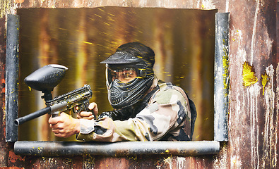 Image showing Paintball, gun and camouflage with a sports man playing a military game for fun or training outdoor. War, soldier and target with a male athlete shooting a weapon outside during an army exercise