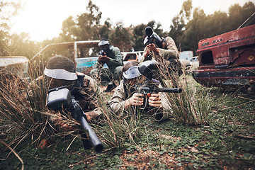 Image showing Paintball, camouflage and team playing a match for fun, fitness and extreme sports with guns. Army, weapons and group of military people practicing or training for a game on an outdoor battlefield.