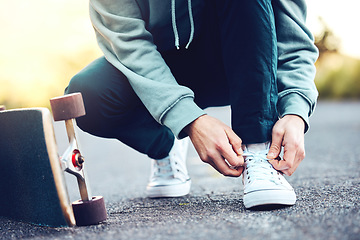 Image showing Hands, skater and man tie shoes on street to start fitness, training or workout. Sports, skateboarding and male with skateboard, tying sneaker laces on road and getting ready for exercise outdoors.