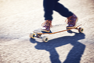 Image showing Feet, skateboard and man skating on road for fitness, exercise and wellness. Training sports, shoes and legs of male skater on board, skateboarding or riding outdoors for balance or workout on street