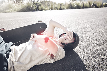 Image showing Pain, skateboarder and man with arm injury on road after fall, accident or exercise workout outdoors. Sports emergency, skating and crying male with bleeding elbow, painful wound and broken bones.