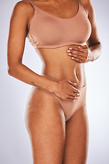 Image showing Stomach, wellness and woman in studio for diet, weight loss and detox against a grey background. Hands, belly and girl model feeling results of liposuction, tummy tuck or cosmetic treatment isolated