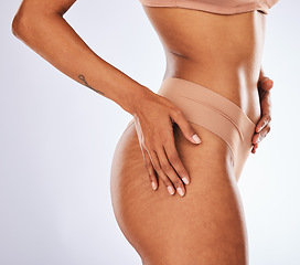 Image showing Stretch marks, buttocks and underwear with a model black woman in studio on a gray background for body positivity. Cellulite, real and natural with a female posing in lingerie from the side