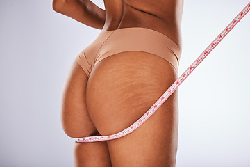 Image showing Measuring tape, woman and butt in studio for weight loss, diet and health progress on grey background. Tape, size and girl model check, measure and slimming results while posing in underwear isolated