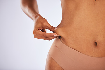 Image showing Stomach, hands and woman in studio for weight loss, liposuction and diet against grey background. Hand, pinch and girl model feeling results on body or skin, tummy tuck and detox while isolated