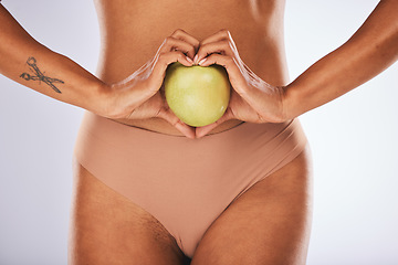 Image showing Health, heart shape and woman with a apple for a healthy, nutrition and organic diet snack. Fitness, wellness and slim female body with love hand gesture for fruit for weightloss by studio background