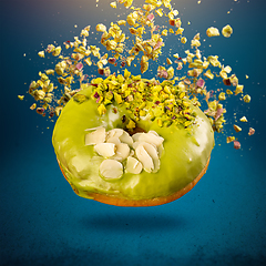 Image showing Glazed donut with flying pistachio