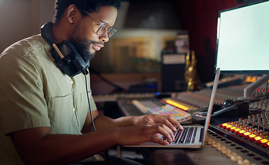 Image showing Black man, thinking and laptop for music recording, sound engineering or song composition in studio. Producer, DJ and musician on technology with ideas for live streaming radio, audio or media album