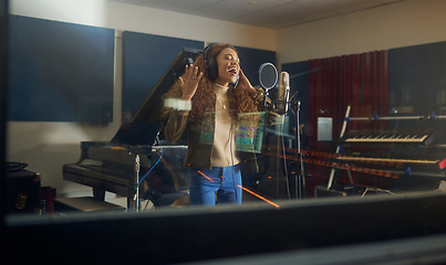Image showing Headphones, singing or musician with studio microphone in album recording, evening audio or radio music at night. Singer, woman or artist in production song, voice media or sound performance practice