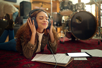 Image showing Music, musician headphones and woman in studio streaming podcast, song or radio online. Relax, meditation and black female artist listening to audio recording while lying on floor with mockup tablet.