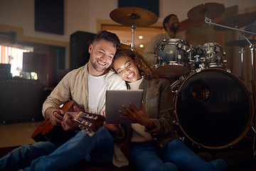 Image showing Guitar, musician couple and tablet in studio for music production or social media. Musicians, diversity love and happy man and woman with acoustic instrument and technology for web scrolling at night