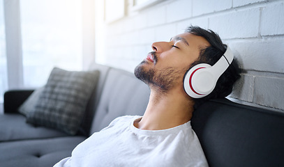 Image showing Relax, music and man with headphones on sofa in home living room streaming radio or podcast. Meditation, technology and male on couch in lounge listening to peaceful song, audio or album in house.