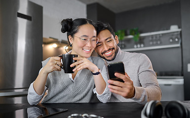 Image showing Love, coffee and couple with phone in home kitchen watching video online. Social media, tea and diversity of man and woman with mobile smartphone streaming movie or film and bonding at night in house