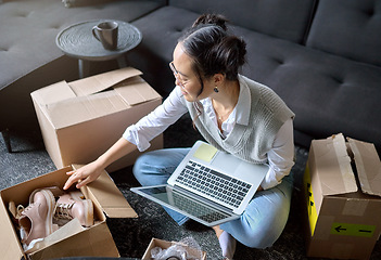 Image showing Laptop, real estate and woman moving into new home while unboxing boxes with shoes. Relocation property, computer and top view of Asian female or house owner opening box of footwear in living room.