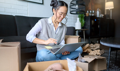 Image showing Real estate, laptop and Asian woman moving into new home while planning or calculating mortgage online. Relocation boxes, computer and female property owner or remote worker in living room of house.