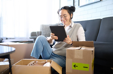 Image showing Tablet, real estate and Asian woman moving into new home while planning or calculating mortgage online. Relocation boxes, technology and female property owner or remote worker in living room of house