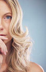 Image showing Half face, hair care and beauty of woman in studio isolated on a blue background. Makeup cosmetics, portrait or female model with beautiful curly hairstyle after salon treatment for growth or texture