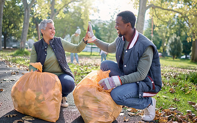 Image showing High five, volunteer or team celebrate cleaning garbage pollution, waste product or environment support. Plastic bag container, NGO charity help or eco friendly community done with nature clean up