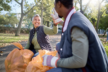 Image showing Volunteer, community service and team high five for cleaning park with bag for a clean environment. Happy man and woman helping with trash or garbage for eco friendly recycling outdoor in nature