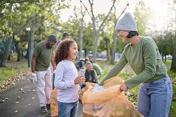 Image showing Trash volunteer, happy woman and child cleaning garbage, pollution or waste product for community environment support. Plastic bag container, NGO charity and nature park clean up by eco friendly kid