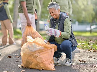 Image showing Trash, volunteer and elderly woman cleaning garbage, pollution or waste product for environment support. Plastic bag container, NGO charity and eco friendly community help with nature park clean up