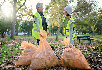 Image showing Volunteer women, community service and cleaning park with garbage bag for a clean environment. Team talking and helping with trash for eco friendly lifestyle and recycling project outdoor in nature