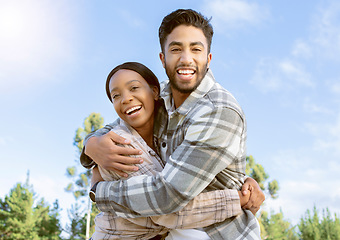Image showing Portrait, couple of friends and hug while hiking in nature, forest and park. Diversity, man and woman embrace outdoors for journey, travel and adventure together on blue sky with love, smile or care