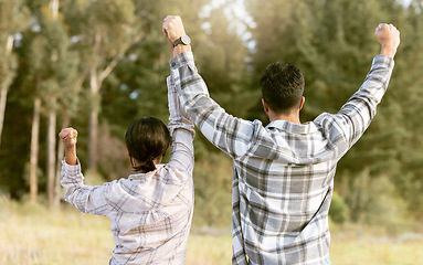 Image showing Back, hiking and couple holding hands for success, victory and achievement, fitness and goals in forest. Rear view, freedom and man with woman celebrating milestone, journey and adventure in nature