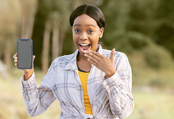 Image showing Mockup, smartphone and black woman surprise in nature or park portrait for announcement or sale on mobile app. African person cellphone, mock up screen and wow on face for product placement in forest