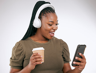 Image showing Music, coffee and surprise with a black woman in studio on a gray background listening to the radio. Phone, social media or headphones and a young female streaming an audio playlist with a drink