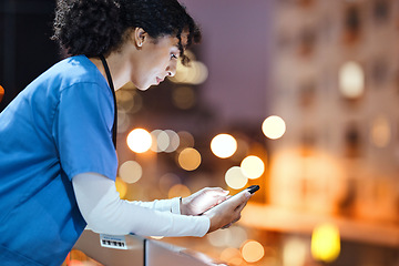 Image showing Night, doctor and woman texting in city while on a break, internet and search against a bokeh background. Nurse, female and online app for schedule, calendar and planner while relaxing on a balcony