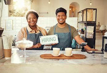 Image showing Portrait, collaboration and hiring sign by small business owners happy at coffee shop or cafe in support together. Team, recruitment and friends due to startup growth due to vacancy, join us or job